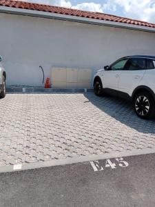 ein weißes Auto parkt auf einem Parkplatz in der Unterkunft APPARTEMENT 4 COUCHAGES in Soustons