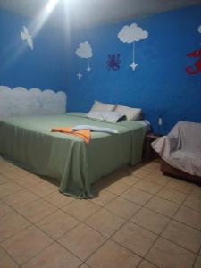a bedroom with a bed with clouds on the wall at Casa Zope in Panajachel
