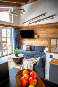 a living room with a blue couch and a tv at Turracher Zirbenlodges in Turracher Hohe