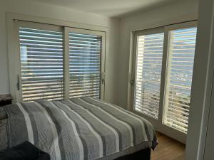 - une chambre avec un lit et 2 grandes fenêtres dans l'établissement Penthouse - Villa Cardano, à Côme