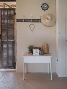 a table in a room with a hat and a clock at Bassiviere Barn Chic in Saint-Étienne-de-Villeréal