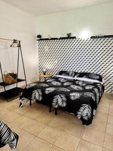 una camera da letto con un letto con un piumone bianco e nero di Agriturismo Corte San Girolamo a Mantova