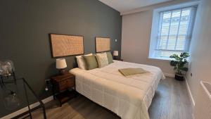 a bedroom with a large bed and a window at St John's Apartments in Perth