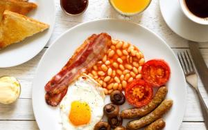 un plato de desayuno con huevos con judías y tocino en The White Horse Inn, en Washford