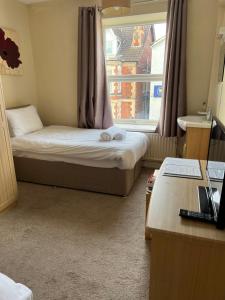 a small room with a bed and a window at The Station Hotel in Worksop