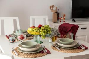 una mesa con platos y tazones de fruta. en Islamar Islantilla Suites, en Islantilla