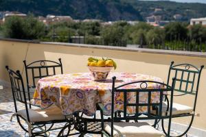 - une table avec un bol de fruits sur le balcon dans l'établissement Sorrento Realty Holidays Pinnidys House, à Sorrente