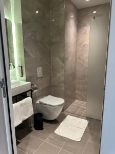 uma casa de banho com um WC, um lavatório e um chuveiro em OZO Hotels Antares Airport em Hoofddorp