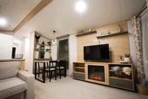 a living room with a tv and a fireplace at Inviting 3-Bed Lodge in Preston hot tub in Preston
