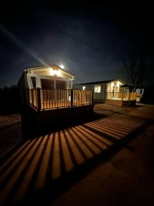 a house with a lit up deck at night at Inviting 3-Bed Lodge in Preston hot tub in Preston
