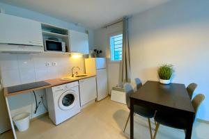 a small kitchen with a table and a washing machine at Les Naïades G37- 2 bedrooms for 5 people ! in Avène