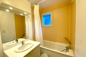 a bathroom with a sink and a tub and a mirror at Les Naïades G37- 2 bedrooms for 5 people ! in Avène