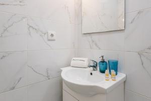 Baño blanco con lavabo y espejo en GuestReady - Mystic Subdual, en Oporto