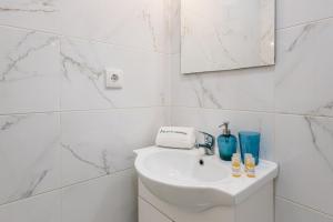 a white bathroom with a sink and a mirror at GuestReady - Mystic Subdual in Porto