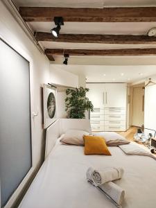 una camera da letto con un grande letto bianco con due asciugamani di Saint-Germain-Des-Près Love Story a Parigi
