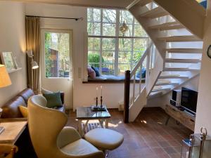 ein Wohnzimmer mit einer Wendeltreppe und einer Couch in der Unterkunft Ferienwohnung Kurparkhaus 19c Wyk in Wyk auf Föhr