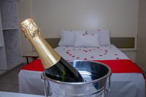 eine Flasche Champagner in einem Eimer neben einem Bett in der Unterkunft Plaza Prestige Hotel Manaus in Manaus
