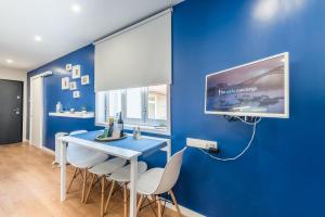 GuestReady - Theater Apartment في بورتو: غرفة طعام بجدران زرقاء وطاولة وكراسي زرقاء