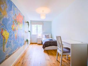 a bedroom with a desk and a large world map on the wall at Light & Airy - Free Parking - Wonderful Location - Sleeps 5 in London