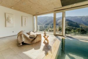 uma sala de estar com uma piscina e uma grande janela em Arantza Hotela- Adults Only em Arantza