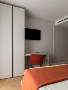 una camera con letto, scrivania e sedia rossa di Le Terrazze Suites a Bari