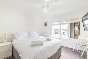 a bedroom with a large white bed and a window at Kingsmere in Horning
