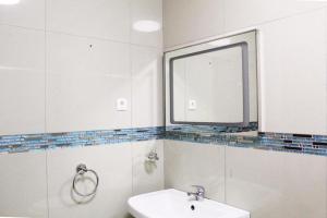 a white bathroom with a sink and a window at Matola View Residence in Matola