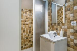 ein Bad mit einem Waschbecken und einer Dusche mit einem Spiegel in der Unterkunft GuestReady - Blue Stripes in Porto