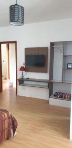 Royal Residency في بلين مانيان: غرفة معيشة مع تلفزيون وأرضية خشبية