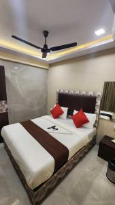 a bedroom with a large bed with red pillows at Hotel Vaithi Residency - Andheri West in Mumbai