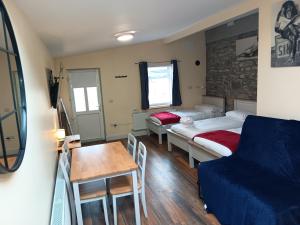 a room with two beds and a table and a couch at Matty's Pub - Apartment's in Carlow