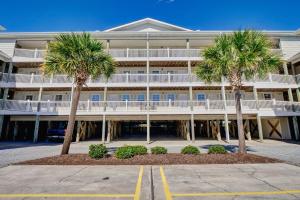 a large building with palm trees in front of it at Unit 304S at Tiffany's in Surf City