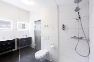 biała łazienka z prysznicem i toaletą w obiekcie Wildgrün Panorama Lodge 15 w mieście Pfronten