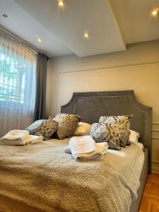 - une chambre avec un lit doté d'oreillers et d'une fenêtre dans l'établissement Apartament De Luxe - Viva pod Giewontem Apartamenty, à Zakopane