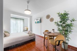 a bedroom with a bed and a table with a plant at GuestReady - Portrait with a view in Porto