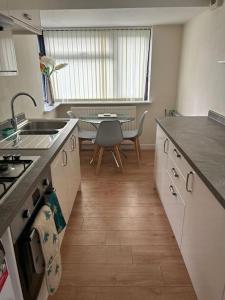 eine Küche mit einem Waschbecken und einem Tisch darin in der Unterkunft 3 Bed House with free parking in Wolverhampton