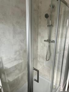 a shower with a glass door in a bathroom at 3 Bed House with free parking in Wolverhampton