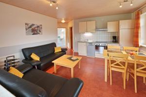 a living room with a couch and a table and a kitchen at Ferienweingut Ulrich Göbel in Ernst +8 photos