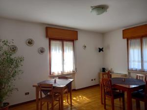 a dining room with two tables and chairs and windows at B&B Primo Marzo in Volargne
