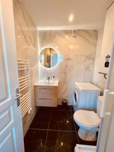 y baño con aseo, lavabo y espejo. en Le Golden Garden en Montluçon