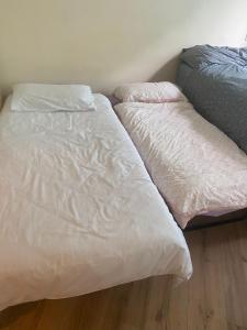 two beds sitting next to each other in a bedroom at Dublin Airport Big rooms with bathroom outside room - kitchen only 7 days reservation in Dublin