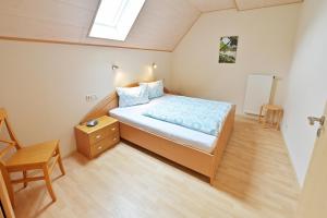 a small bedroom with a bed and a chair at Ferienweingut Ulrich Göbel in Ernst
