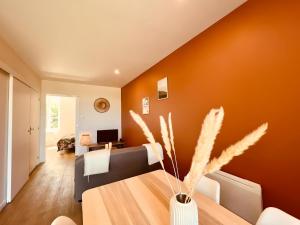 een woonkamer met oranje muren en een tafel bij Le Sweet Terracotta in Montluçon