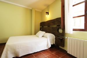 a bedroom with a white bed and a window at Hotel Rural Frías in Trias