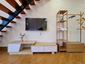 a living room with a tv on a wall at VILLA MINH HẬU in Cu Lao Thu