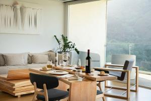 a living room with a table with wine bottles and chairs at Arantza Hotela- Adults Only in Arantza