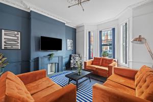 ein Wohnzimmer mit orangefarbenen Möbeln und blauen Wänden in der Unterkunft Fabulous House in Plymouth in Plymouth