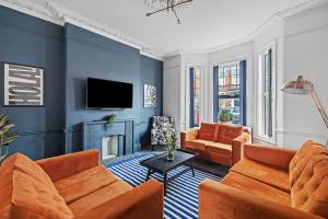 a living room with orange furniture and blue walls at Fabulous House in Plymouth in Plymouth