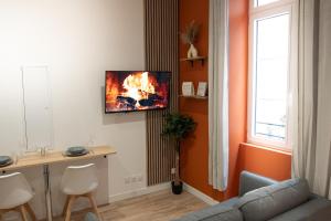 a living room with a couch and a fire on the wall at Le Cocon Urbain in Millau