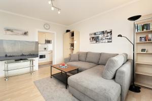 uma sala de estar com um sofá e uma mesa em Ferienwohnung 18 mit Balkon im Haus Achtern Diek em Grömitz